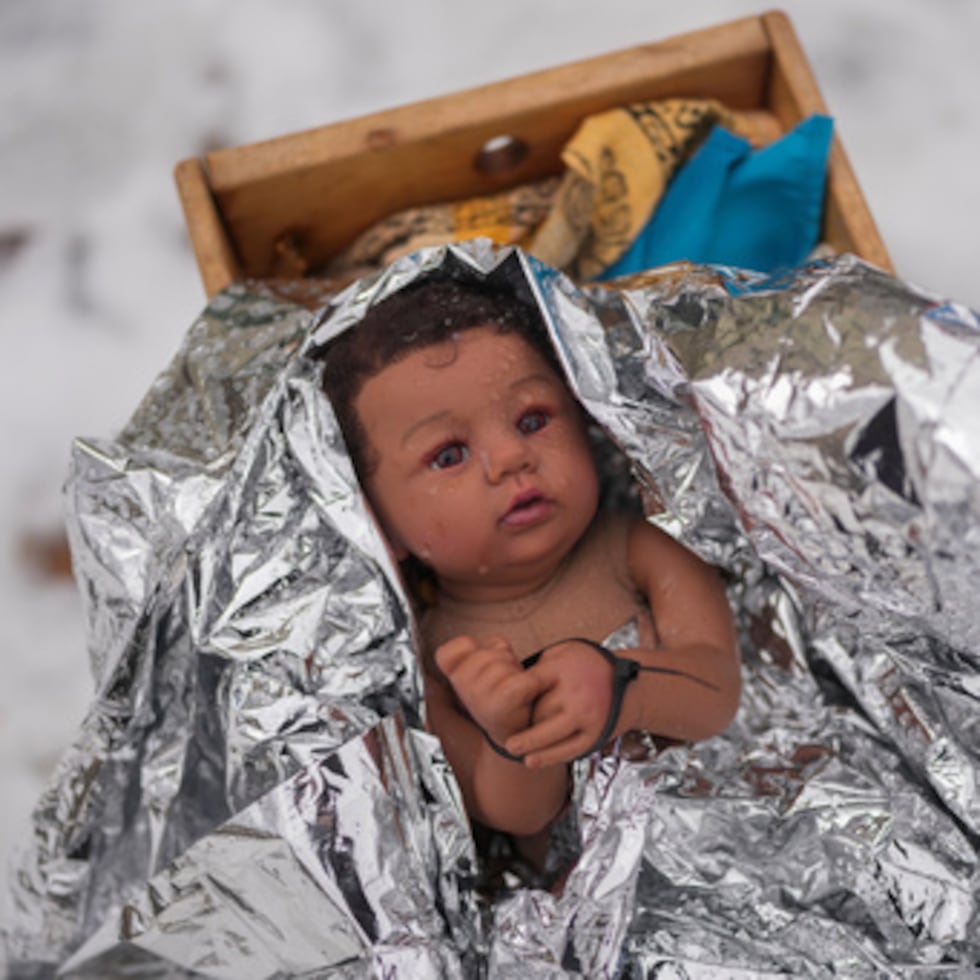 Un muñeco que representa al niño Jesús es atado con una cremallera en la escena de la Natividad fuera de Lake Street Church de Evanston, miércoles, 10 de diciembre de 2025, en Evanston, Illinois.