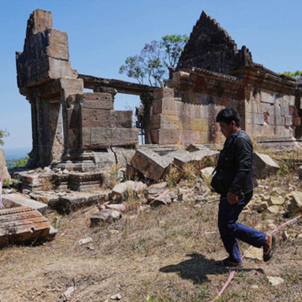 Agentes de policía camboyanos caminan junto a un templo dañado durante los enfrentamientos fronterizos con Tailandia, en la provincia de Preah Vihear, Camboya.
