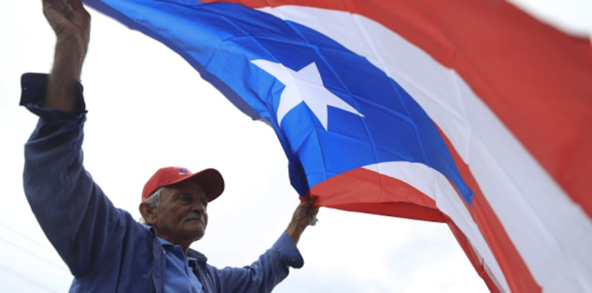 Don Rafael Rodríguez, de 74 años y natural de Corozal, explica que los clientes le han comentado que buscan “echar pa’lante” el país al exhibir la monoestrellada. (teresa.canino@gfrmedia.com)