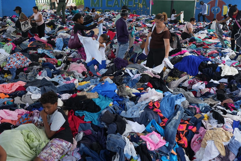 Personas eligen ropa donada para los damnificados por los terremotos en un complejo deportivo, el sábado 4 de julio de 2026, en La Guaira, Venezuela. (AP Foto/Ariana Cubillos)