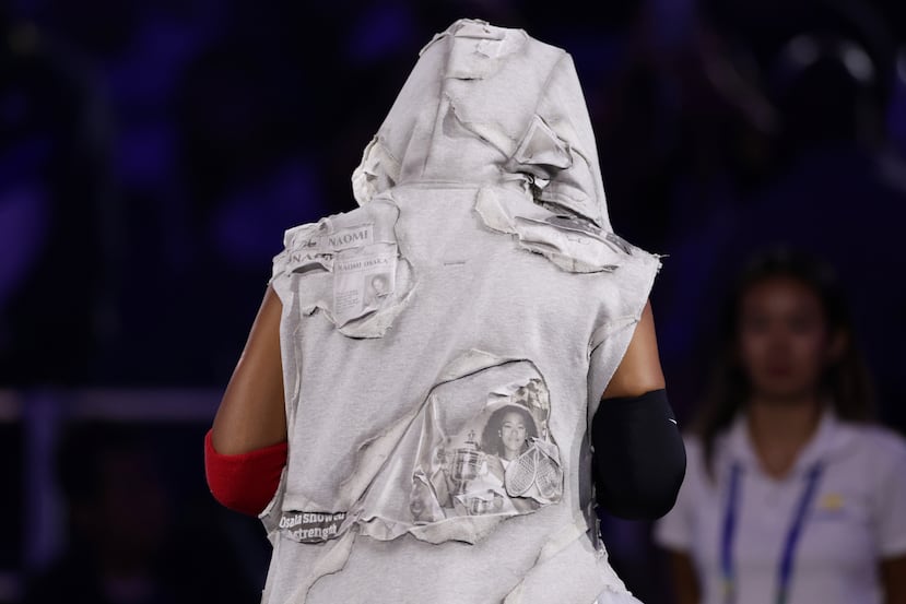 La dos veces campeona del US Open salió del túnel a la pista del estadio Arthur Ashe con una falda larga blanca y una bata gris con capucha en la que se podían ver recortes de periódico sobre ella.