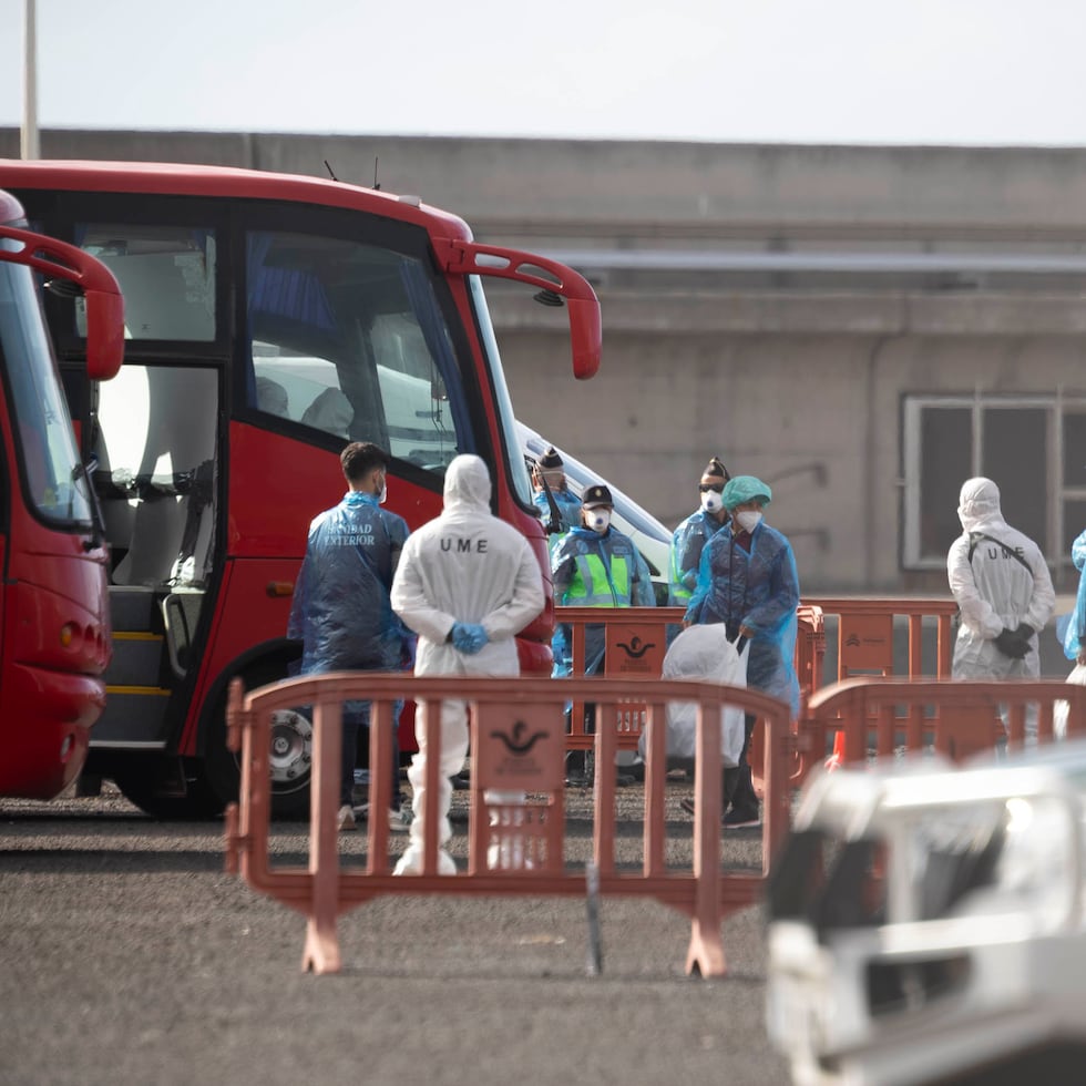 Dos de los pasajeros desembarcados que iban a bordo del crucero neerlandés MV Hondius han desembarcado ya en el puerto de Granadilla de Abona y reciben instrucciones de personal de la Unidad Militar de Emergencias y del Servicio de Sanidad Exterior.