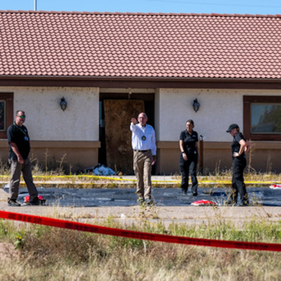 Randy Keller, forense del condado de Fremont, en el centro, y otras autoridades inspeccionan la zona donde planean instalar tiendas de campaña en la funeraria Return to Nature, donde más de 100 cuerpos han sido almacenados indebidamente, en Penrose, Colorado.