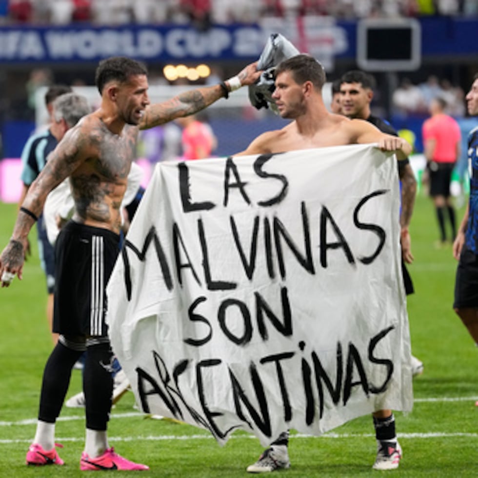El argentino Giovani Lo Celso sostiene una pancarta con el lema "Las Malvinas son argentinas", mientras su compañero de selección, el argentino Nicolás Otamendi, le hace un gesto, al término de la semifinal del Mundial de fútbol entre Inglaterra y Argentina.