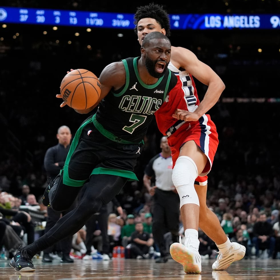Jaylen Brown (7), de los Celtics de Boston, se enfila con el balón hacia la canasta, dejando atrás a Kobe Sanders, de los Clippers de Los Ángeles.