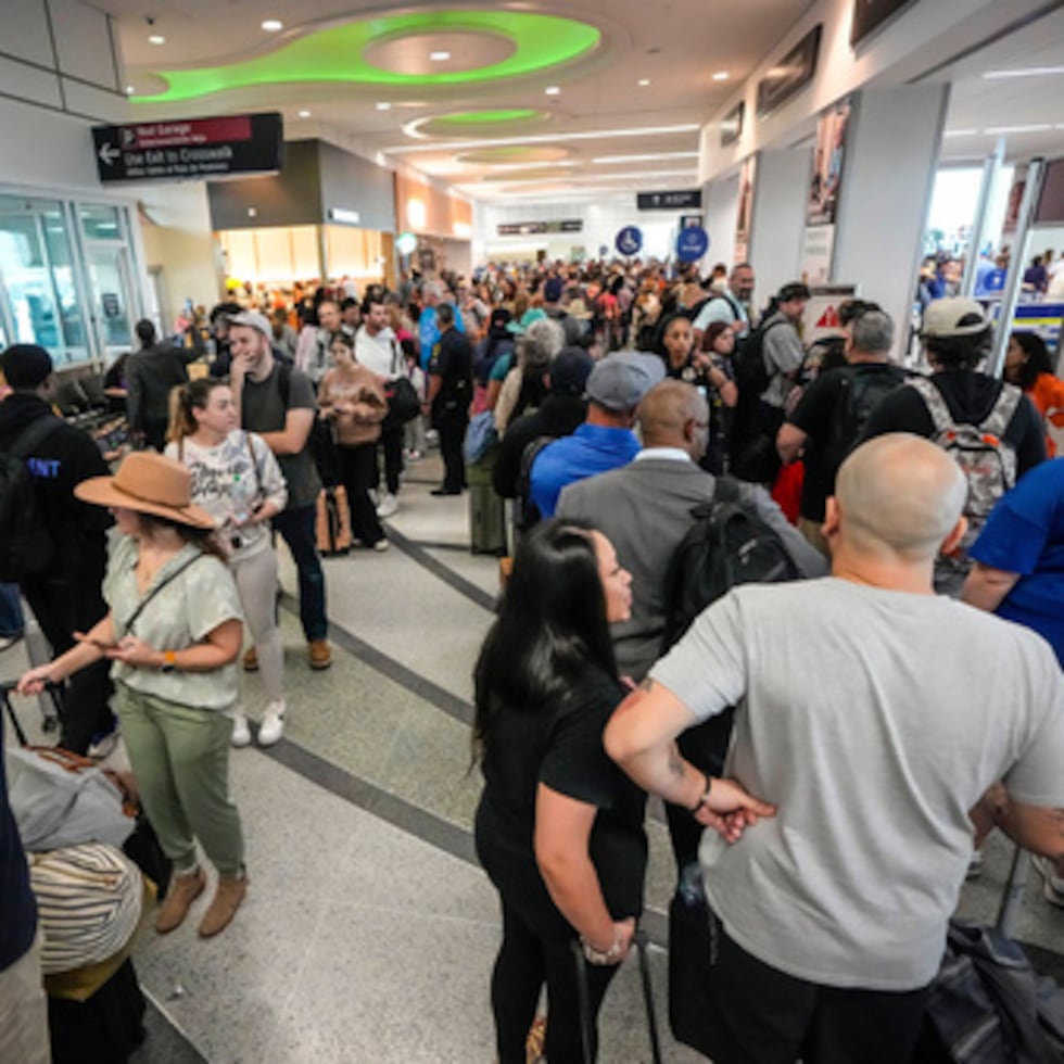 Pasajeros de avión esperan en largas colas para pasar el control de seguridad de la TSA en el aeropuerto William P. Hobby de Houston.