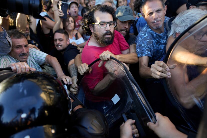 Manifestantes contra el gobierno forcejean con la policía en las afueras del Congreso tras la aprobación en general de la reforma económica promovida por el presidente argentino en la Cámara de Diputados.
