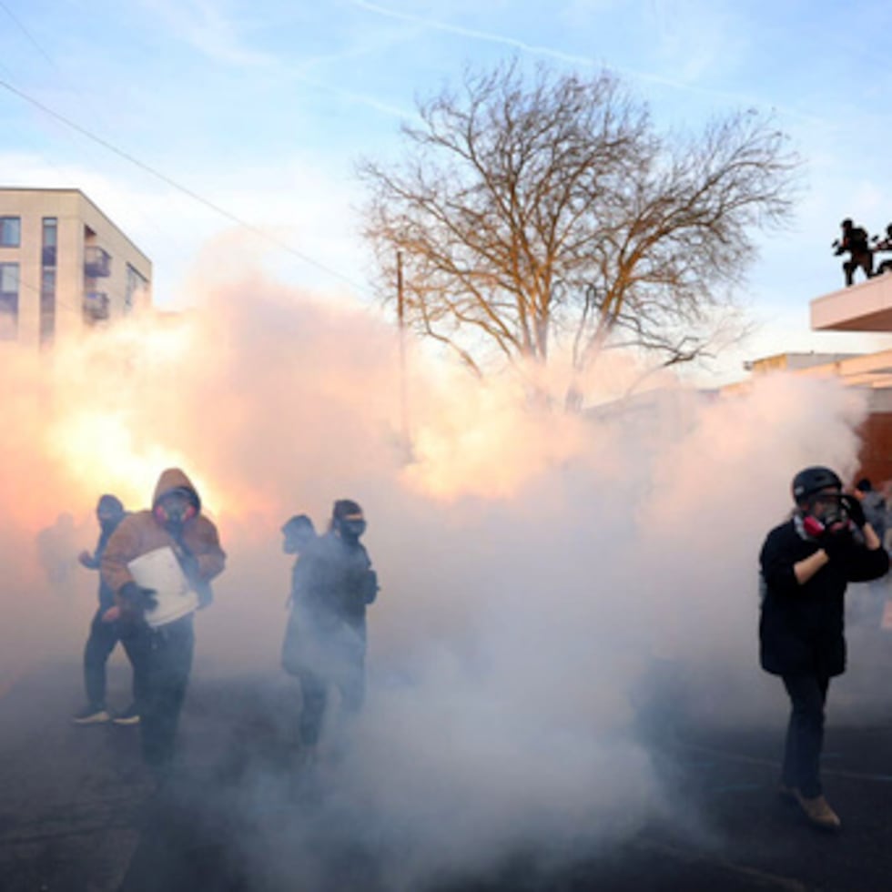 Agentes federales lanzan gases lacrimógenos y granadas aturdidoras contra manifestantes frente al edificio del Servicio de Inmigración y Control de Aduanas de Estados Unidos, en Portland.