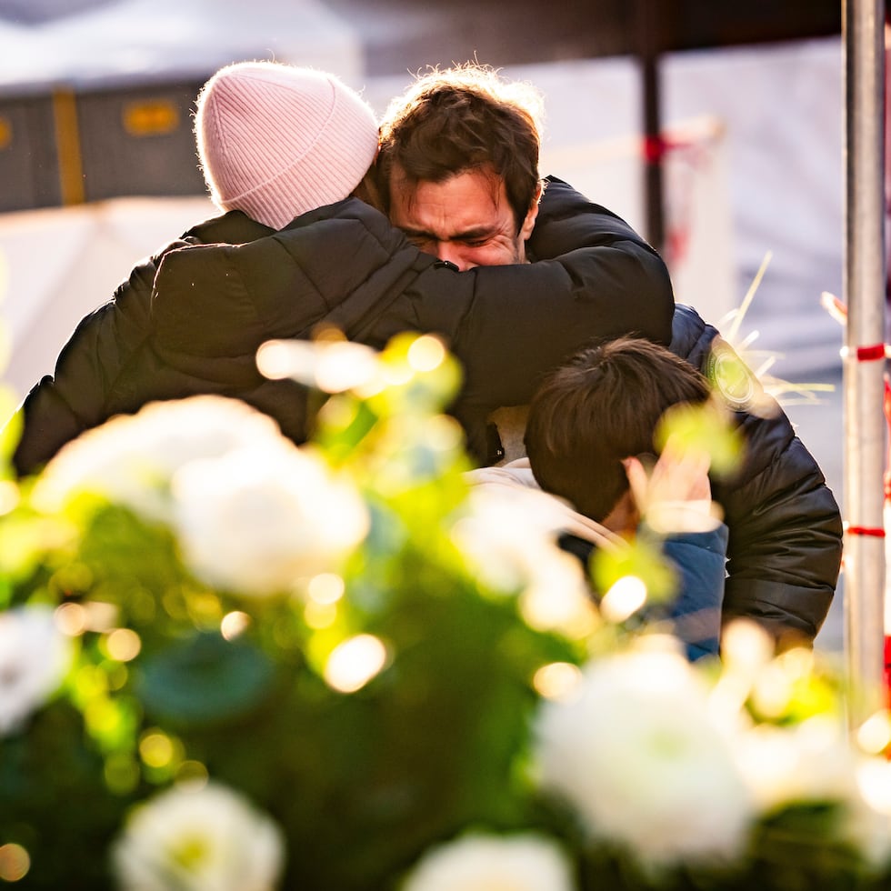 Dos personas lloran abrazadas en las inmediaciones del bar Le Constellation.