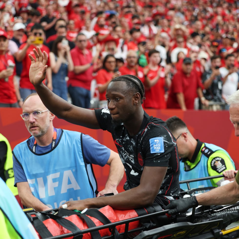 Ismael Koné saluda a la multitud mientras es retirado del campo en camilla tras una lesión.