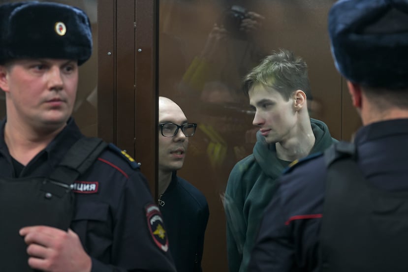 Artyom Kamardin (izquierda) y Yegor Shtovba (derecha), detrás del cristal de la zona de acusados en un tribunal en Moscú, Rusia, el 28 de diciembre de 2023.