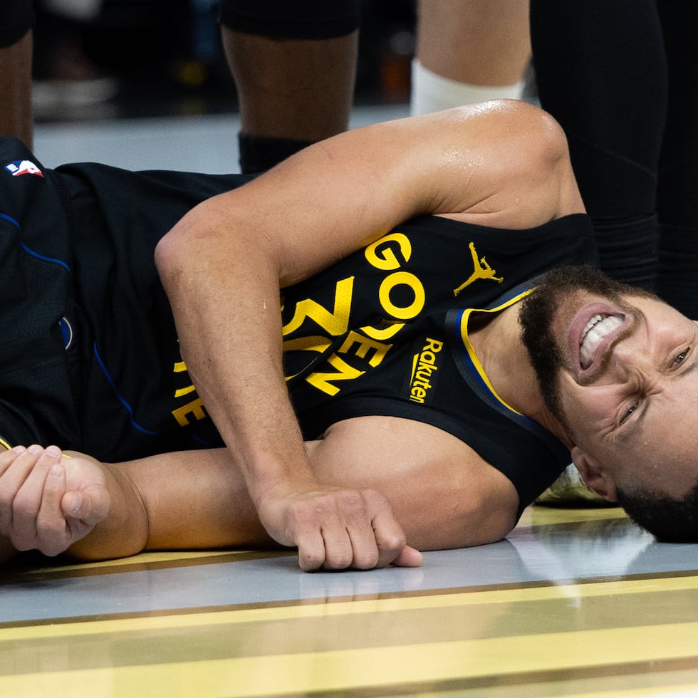 Stephen Curry, base de los Warriors de Golden State, yace en la cancha durante el partido ante los Rockets de Houston, el miércoles 26 de noviembre de 2025 (AP Foto/Benjamin Fanjoy)