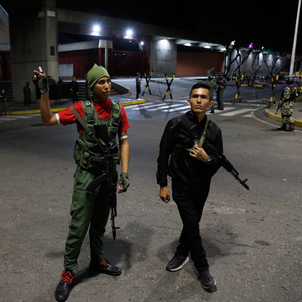 Members of the presidential guard stand outside the Miraflores presidential palace after explosions and low-flying aircraft were heard in Caracas, Venezuela, Saturday, Jan. 3, 2026. (AP Photo/Cristian Hernandez)