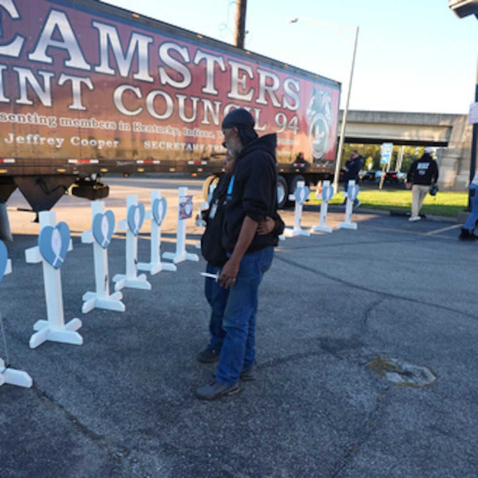 Allen Wilson, a la derecha, abraza a un asistente después de escribir en cruces por las víctimas durante una vigilia el jueves, 6 de noviembre de 2025, en Louisville, Kentucky.