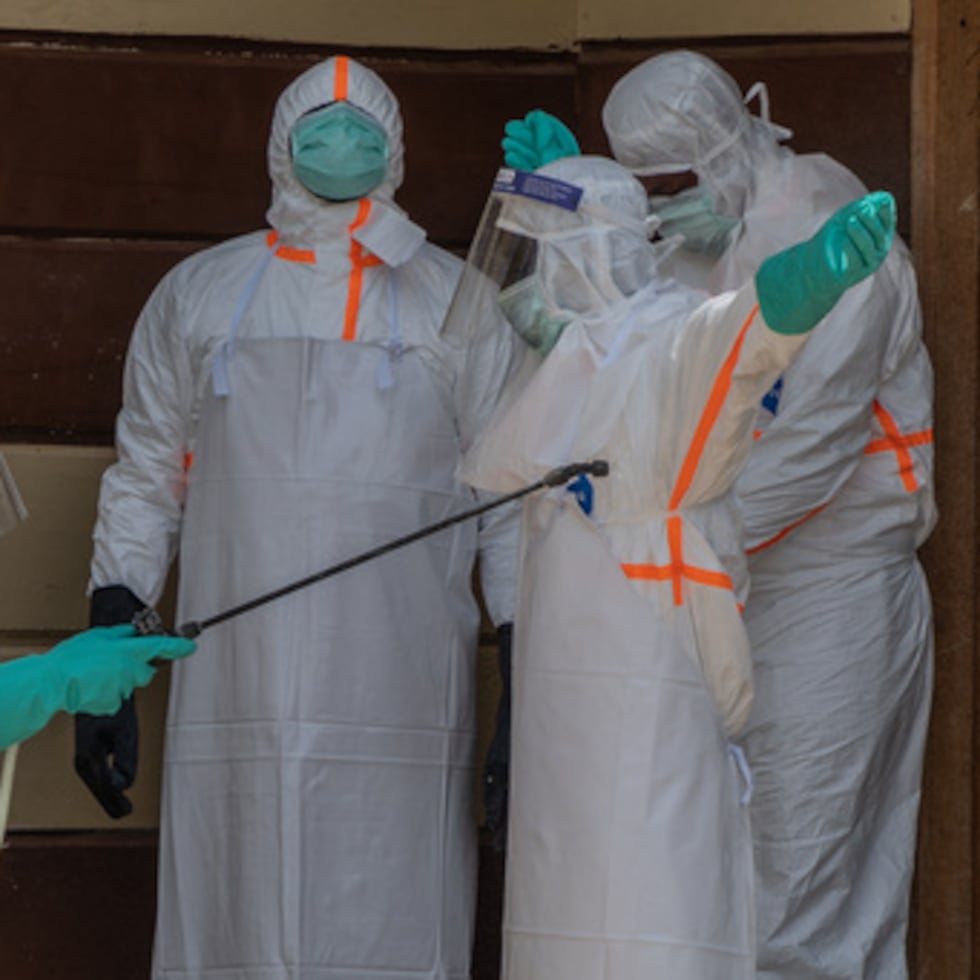 El personal sanitario se desinfecta tras preparar el cadáver de una víctima del ébola en la clínica Citadelle de Bunia, en el Congo.