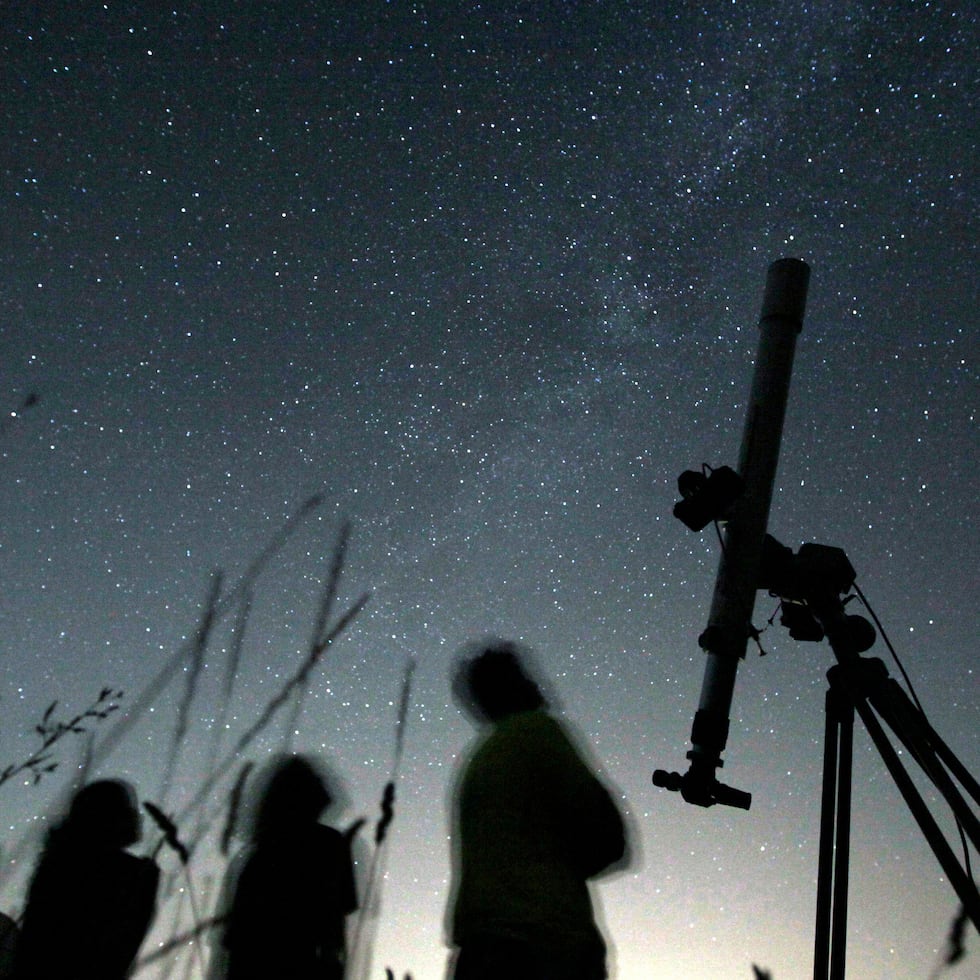 Tres personas miran al cielo desde un observatorio el 12 de agosto de 2009, cerca del pueblo de Avren, Bulgaria. (AP Foto/Petar Petrov, archivo)