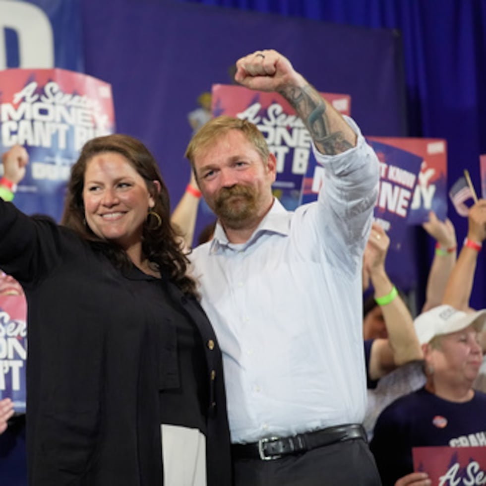 El candidato demócrata al Senado de Estados Unidos, Graham Platner, a la derecha, y su esposa Amy Gertner hacen gestos a sus partidarios durante una fiesta de observación de la noche de las elecciones primarias
