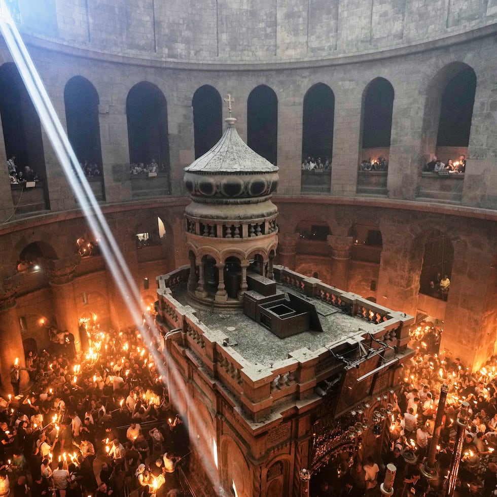 Peregrinos cristianos encienden velas durante la ceremonia del Fuego Sagrado en la Iglesia del Santo Sepulcro, el lugar donde, según la tradición, Jesús fue crucificado y enterrado, en la Ciudad Vieja de Jerusalén.