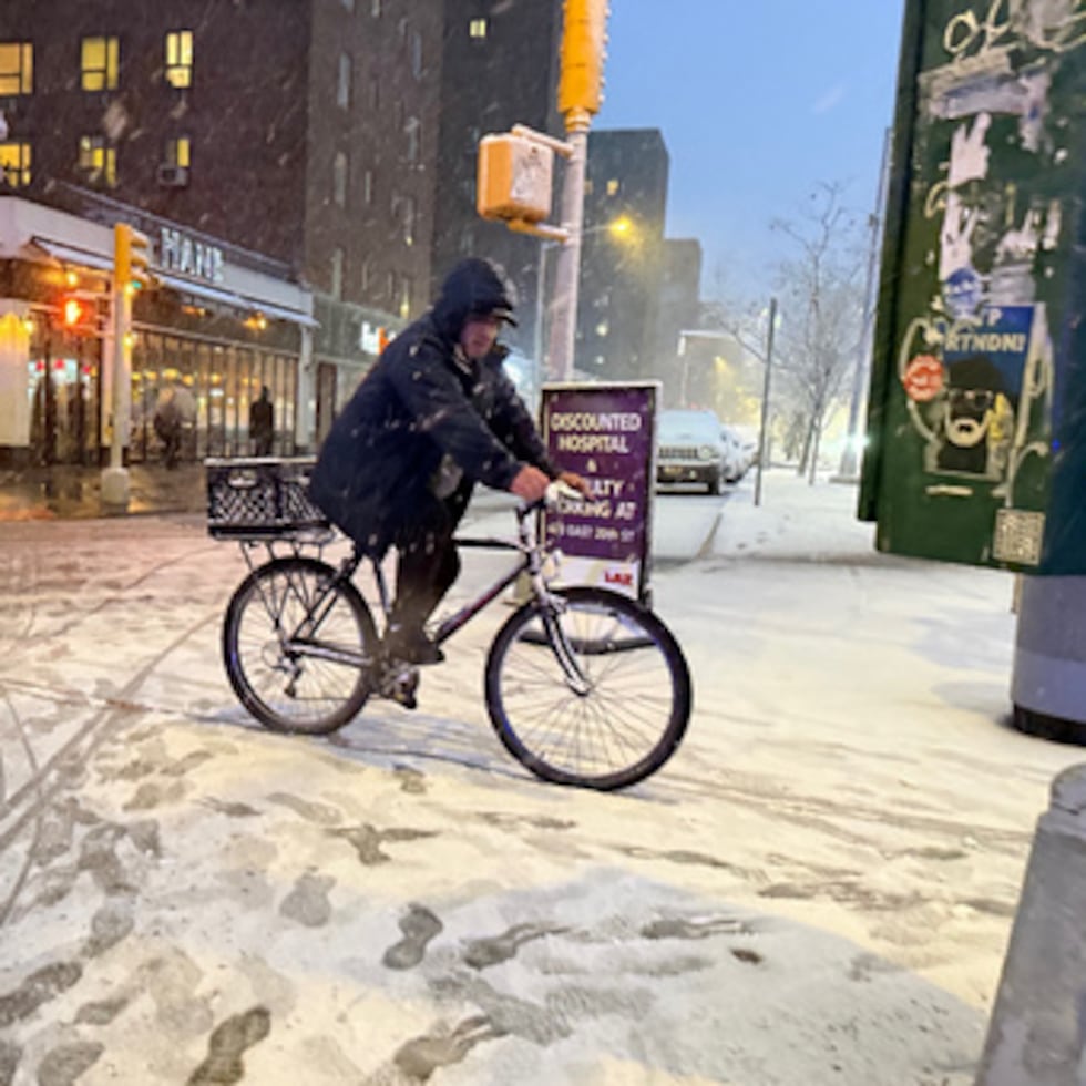 Un hombre circula en bicicleta el domingo, al inicio de una intensa nevada en el cruce entre la calle 20 y la Quinta Avenida, en Nueva York.