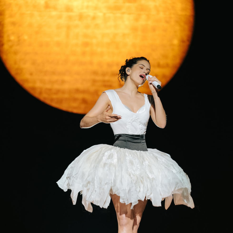 Fotografía cedida por Beth Saravo (@baeth) donde aparece la cantante española Rosalía luciendo un conjunto de Dior de color marfil compuesto por una camiseta sin mangas de punto de cuello redondo y una falda tutú de organza con medallones inspirados en hojas bordados con lentejuelas blancas decorativas y abalorios, que ceñe con un fajín negro, durante el primer concierto de su gira norteamericana, 'LUX Tour 2026', realizado el jueves 11 de junio en Boston, Massachusetts