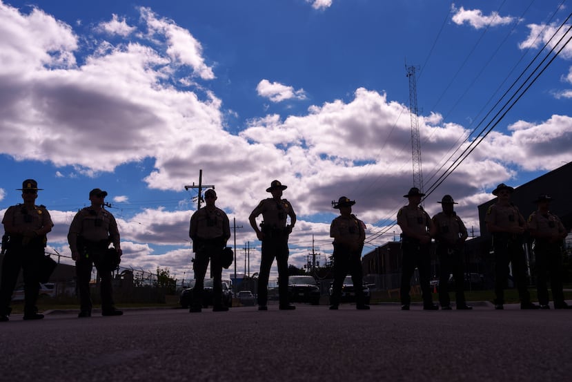 ARCHIVO - Agentes de la policía estatal de Illinois hacen guardia mientras un grupo de personas, incluyendo miembros de la Coalition for Spiritual and Public Leadership (CSPL), se congregan en el exterior de un centro del Servicio de Control de Inmigración y Aduanas en Broadview, Illinois, el 11 de octubre de 2025. (AP Foto/Adam Gray, archivo)