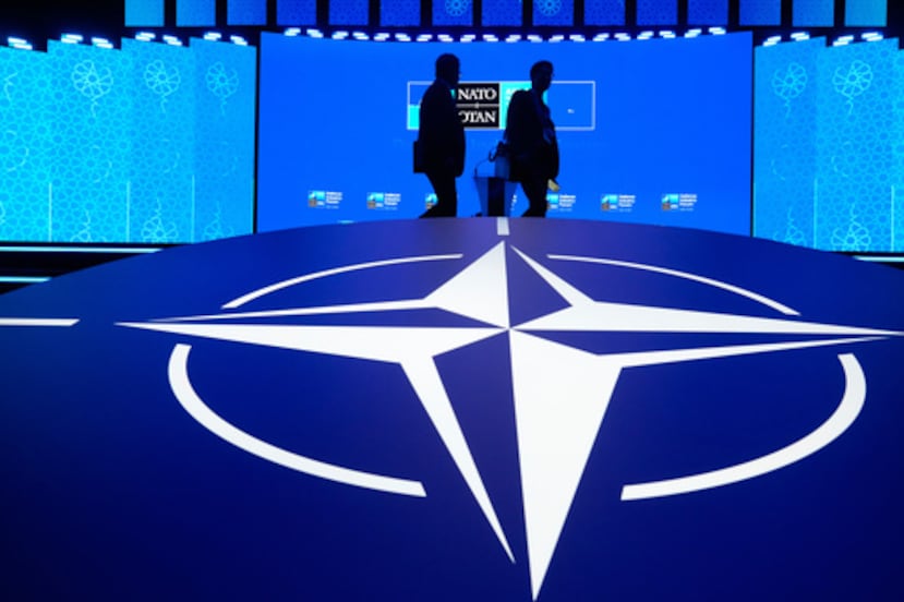 Dos hombres pasan junto al logotipo de la OTAN durante el Foro de la Industria de Defensa celebrado en la cumbre de Ankara, Turquía, el martes 7 de julio de 2026. (Foto AP/Hussein Malla)