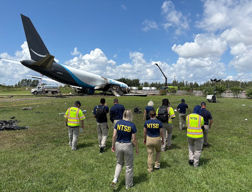Esta imagen divulgada por la NTSB muestra a investigadores de esa agencia en la escena donde un avión de carga de Amazon se accidentó en el Aeropuerto Internacional de Miami.
