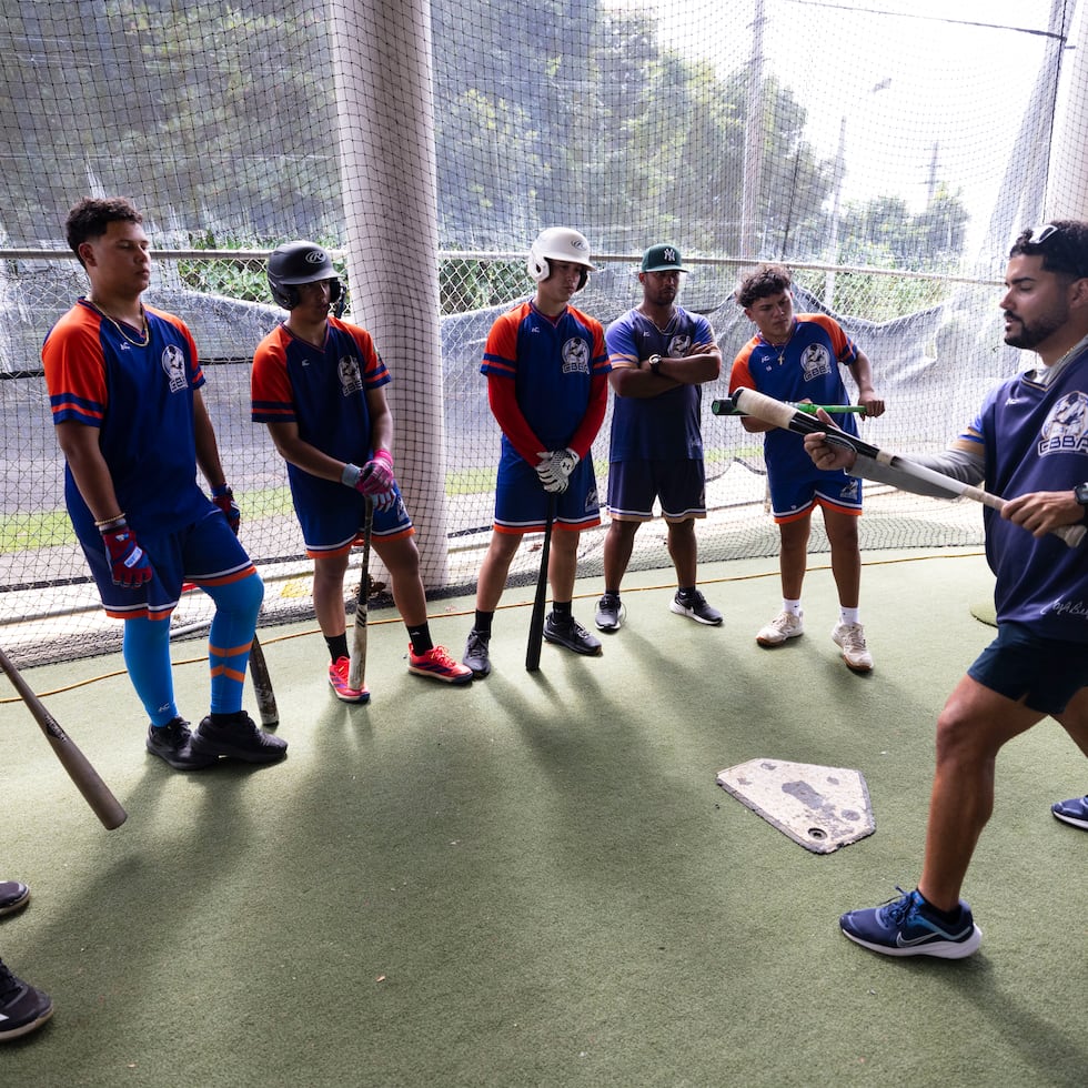Un grupo de estudiantes presta atención a uno de los instructores sobre el fundamento del toque de la pelota en la jornada del miércoles en la academia.