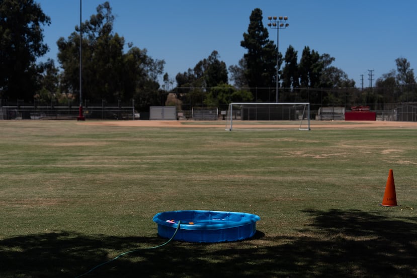 Una pequeña piscina de plástico se llena de agua para que los niños se refresquen en un campo de fútbol en Los Ángeles, el viernes 31 de julio de 2026. (Foto AP/Jae Chong)