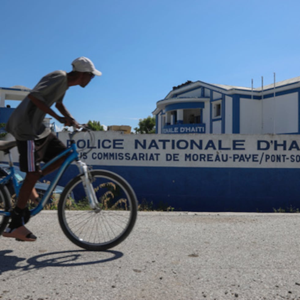 Un hombre monta en bicicleta frente a una comisaría de policía en Pont-Sonde, Haití, 7 de octubre de 2024. (AP Photo/Odelyn Joseph, Archivo)