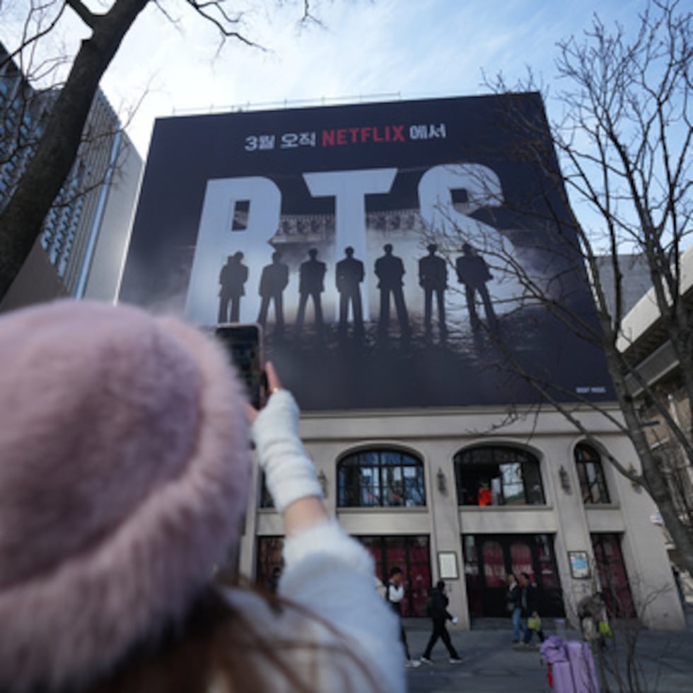 Un fan del grupo de K-pop BTS filma una valla publicitaria de BTS en el centro de Seúl, Corea del Sur, el jueves 19 de marzo de 2026. (AP Photo/Lee Jin-man)