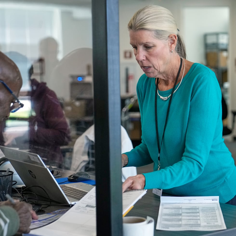 Debbie Lewis, a la derecha, quien recibe votos anticipados, le entrega su boleta a Eddie Johnson, el miércoles 7 de octubre de 2026, en Cleveland. (AP Foto/Sue Ogrocki)