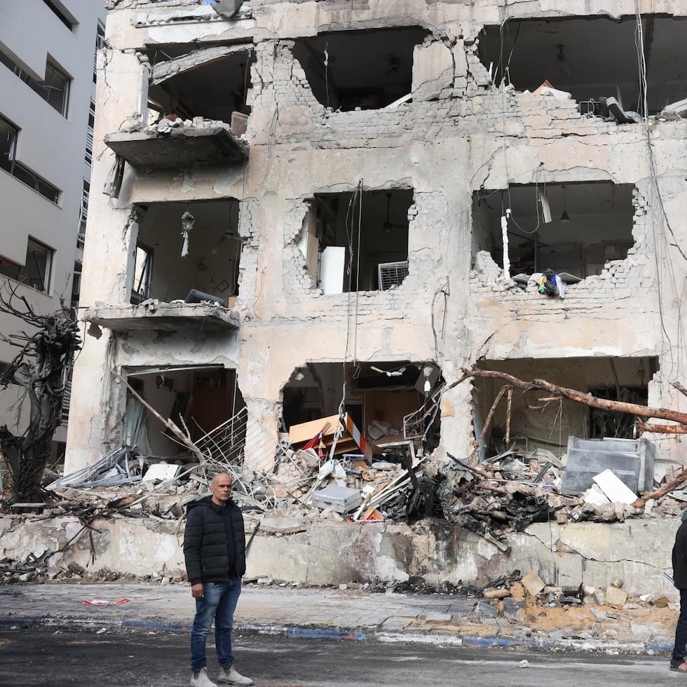 Vecinos frente a un edificio que fue alcanzado por un misil iraní en Tel Aviv, Israel.
