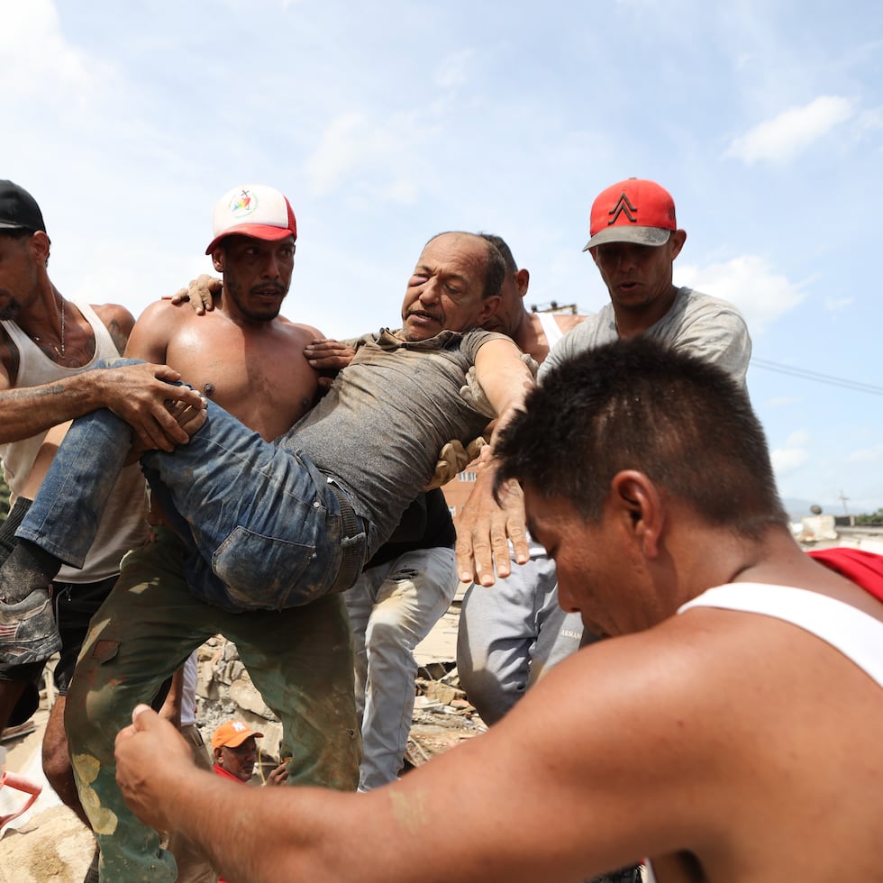 Vecinos transportan a un hombre rescatado de entre los escombros de un edificio derrumbado en La Guaira, Venezuela.