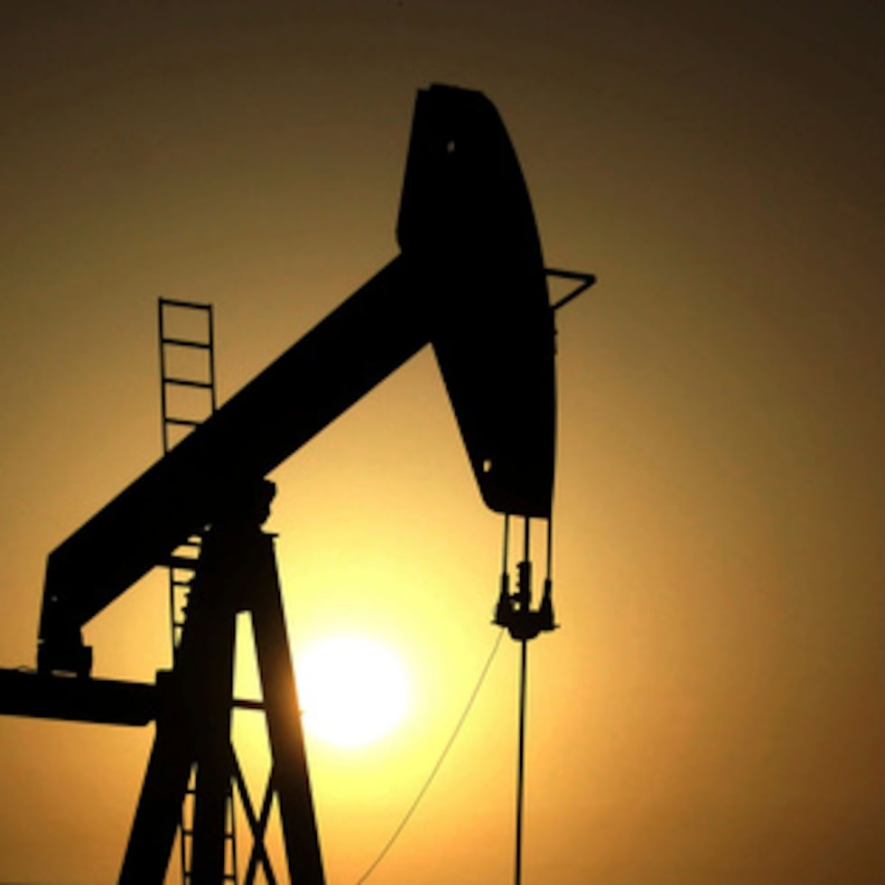 El sol se pone detrás de una bomba de petróleo.