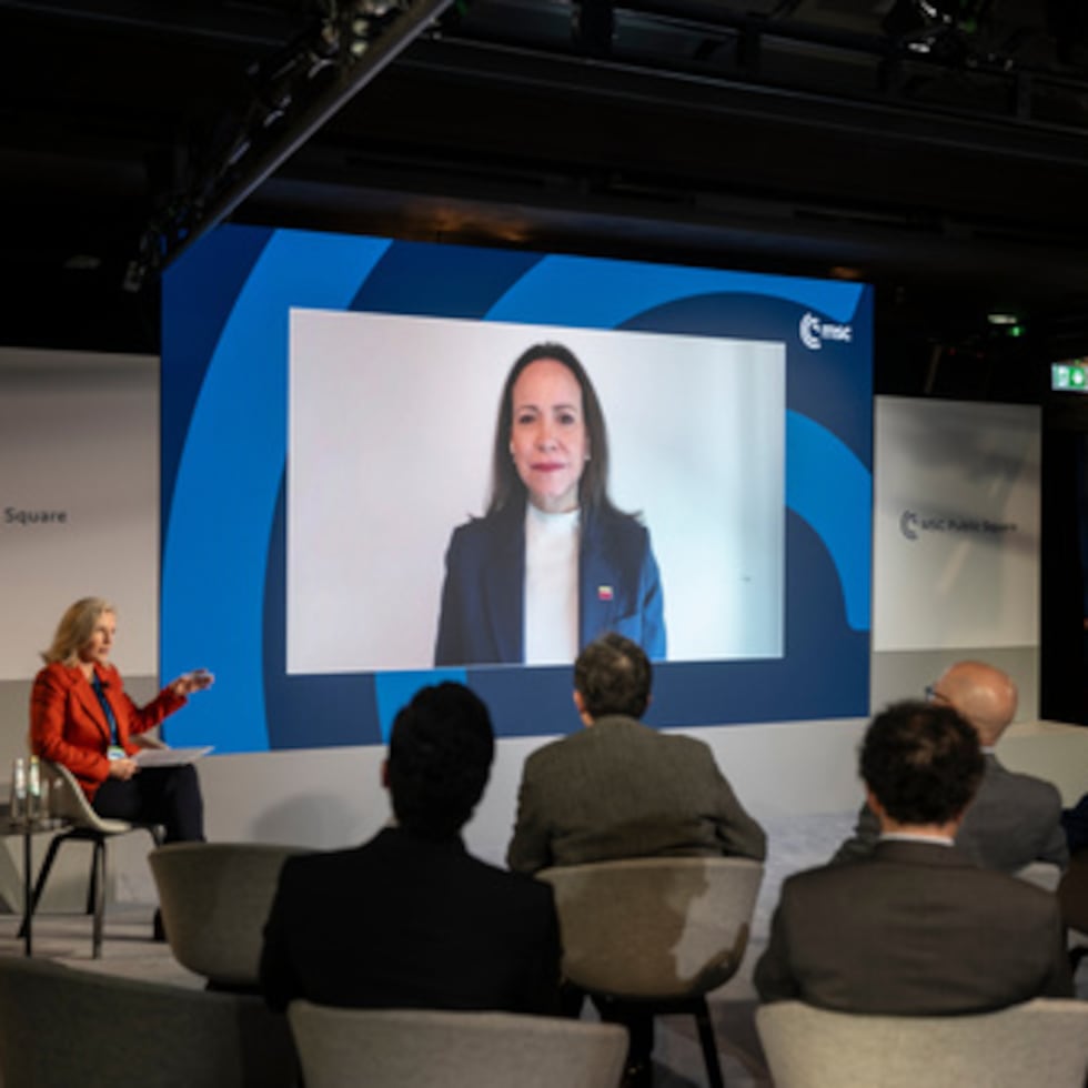 La opositora venezolana María Corina Machado, en la pantalla, participa en la Conferencia de Seguridad de Munich el sábado 14 de febrero de 2026, en esta ciudad de Alemania. (Marijan Murat/dpa vía AP)