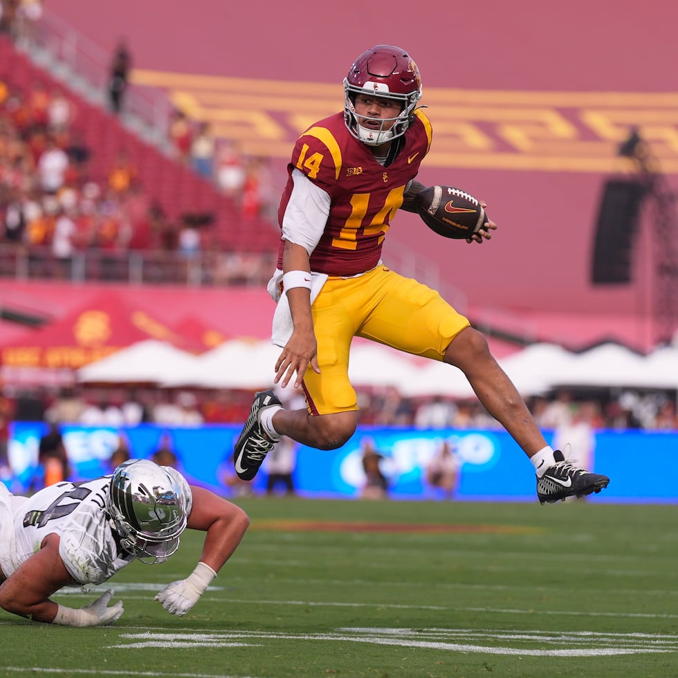 El quarterback de los Trojans de Southern California, Jayden Maiava (derecha), evade al apoyador de los Ducks de Oregon, Teitum Tuioti, durante la primera mitad de un partido de la NCAA el viernes.