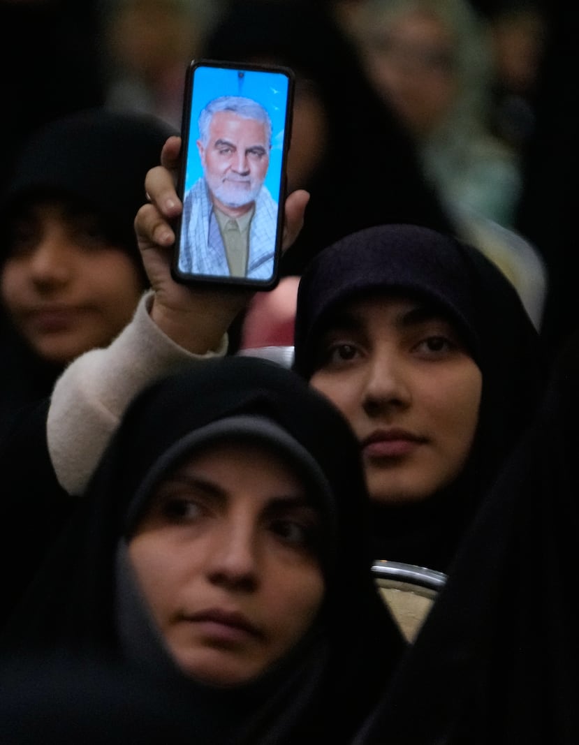 Una mujer muestra en su teléfono inteligente un retrato del difunto comandante de la Fuerza Quds de la Guardia Revolucionaria iraní, el general Qassem Soleimani, quien murió en un ataque con drones estadounidenses en Irak en 2020, durante una ceremonia en conmemoración del aniversario de su muerte en la Gran Mezquita del Imán Jomeini en Teherán, Irán, el jueves 1 de enero de 2026. (Foto AP/Vahid Salemi)