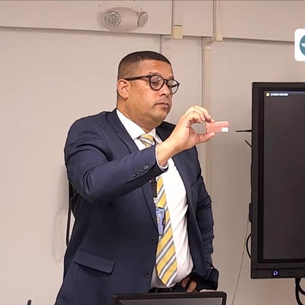 El agente Ángel Torres Romero, adscrito a la División de Homicidios del Cuerpo de Investigaciones Criminales (CIC) de Aibonito, sostiene una parte de una peinilla rosada.