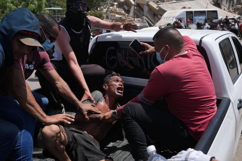 Residentes transportan a un hombre rescatado de entre los escombros tres días después de los terremotos, en La Guaira, Venezuela, el sábado 27 de junio de 2026.