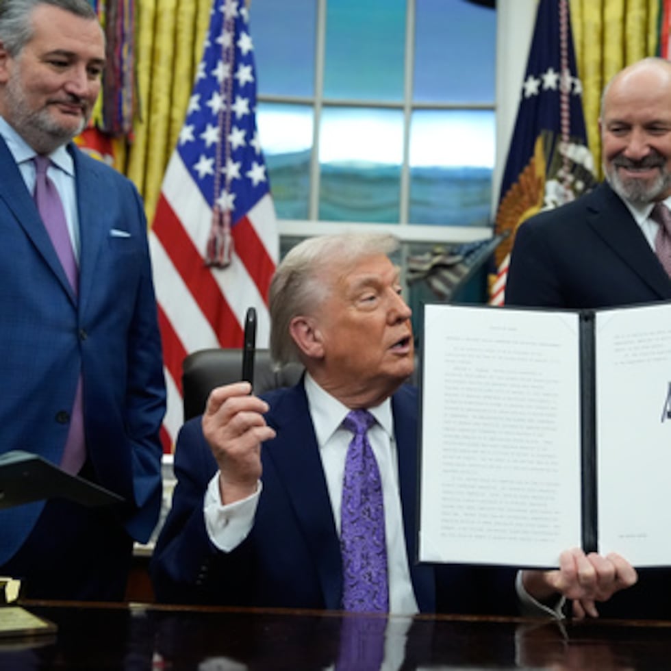 Flanqueado por el senador Ted Cruz, republicano de Texas, a la izquierda, y el secretario de Comercio, Howard Lutnick, el presidente Donald Trump muestra su iniciativa firmada sobre IA en el Despacho Oval de la Casa Blanca, el jueves 11 de diciembre de 2025, en Washington.