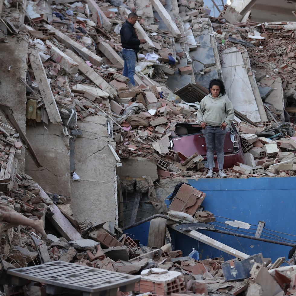 Residentes caminan entre los escombros de edificios derrumbados por los terremotos, en la localidad de Catia La Mar, en el estado costero de La Guaira