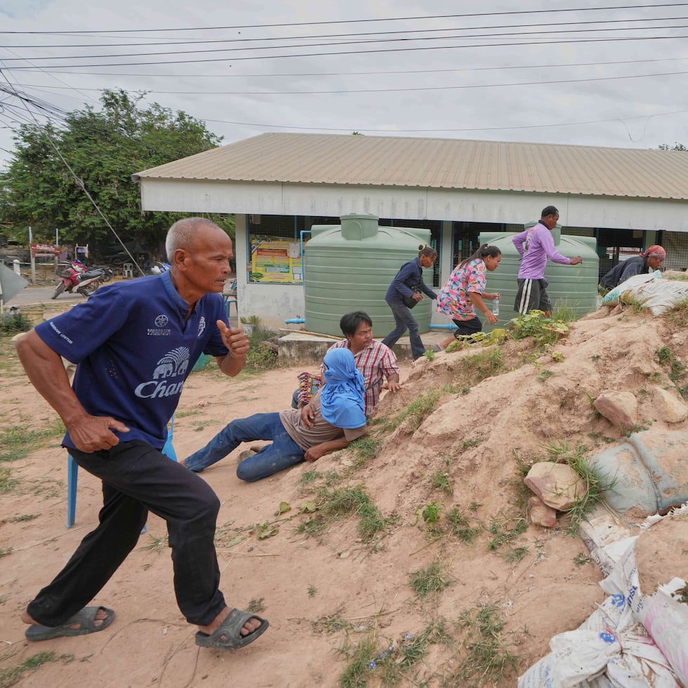 Voluntarios encargados de la seguridad y residentes corren a refugiarse ante la cercanía de las explosiones, en la provincia de Buriram, Tailandia, el 12 de diciembre de 2025, tras la reanudación de los combates entre Tailandia y Camboya.