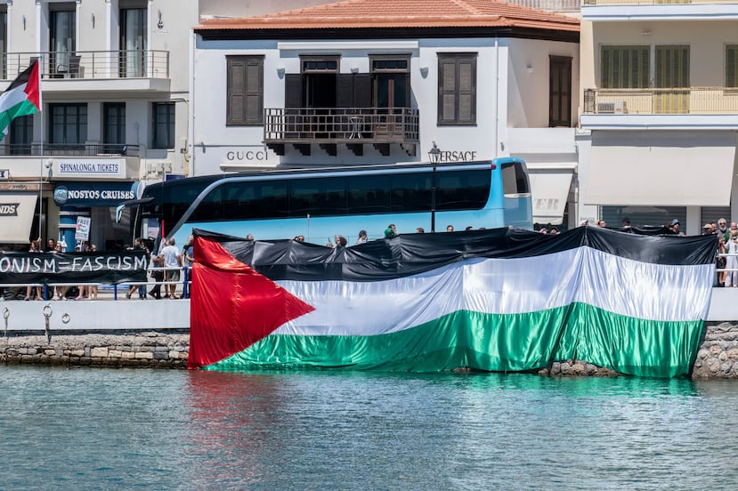 Pro-Palestinians protesters gather during the departure of a ship carrying Israeli tourists, background, in Agios Nikolaos port, on the island of Crete, Greece, Tuesday, July 29, 2025. (Antonis Zouridakis/Eurokinissi via AP)