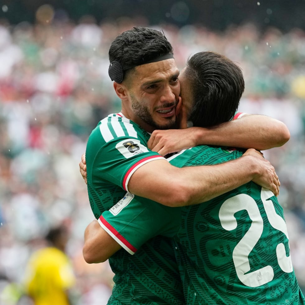 El mexicano Raúl Jiménez abraza a su compañero Roberto Alvarado, a la derecha, tras marcar el segundo gol de su selección durante el partido de fútbol del Grupo A del Mundial entre México y Sudáfrica.