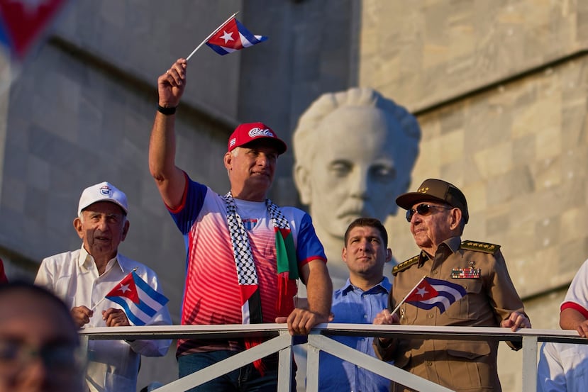 ARCHIVO – El presidente de Cuba Miguel Diaz-Canel ondea una bandera cubana mientras mira el desfile del Día del Trabajo junto a Raúl Castro, segundo de derecha a izquierda, y Raul Guillermo Rodríguez Castro, nieto de Raúl Castro, en la Plaza de la Revolución en La Habana, el 1 de mayo de 2025. (AP Foto/Ramon Espinosa, Archivo)