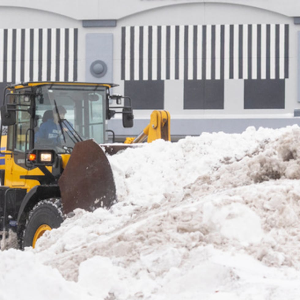 Un operario limpia la nieve de un estacionamiento en Grandville, Michigan.