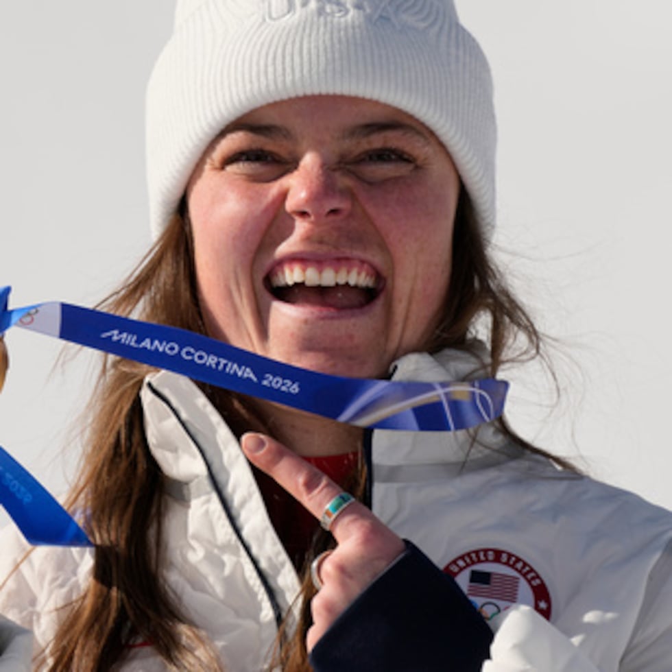 La estadounidense Breezy Johnson muestra su medalla de oro en la prueba femenina de descenso de esquí alpino, en los Juegos Olímpicos de Invierno de 2026, en Cortina d'Ampezzo, Italia, el domingo 8 de febrero de 2026. (AP Photo/Andy Wong)