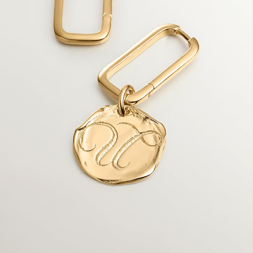 Los "charms" con la inicial o el signo zodiacal pueden colocarse en cadenas, pulseras o en pantallas, que incluyen argollas y dormilonas. Las argollas rectangulares hechas en plata 925 y bañadas en oro 18k cuestan $125 y la inicial, en los mismos materiales, está disponible en $75.