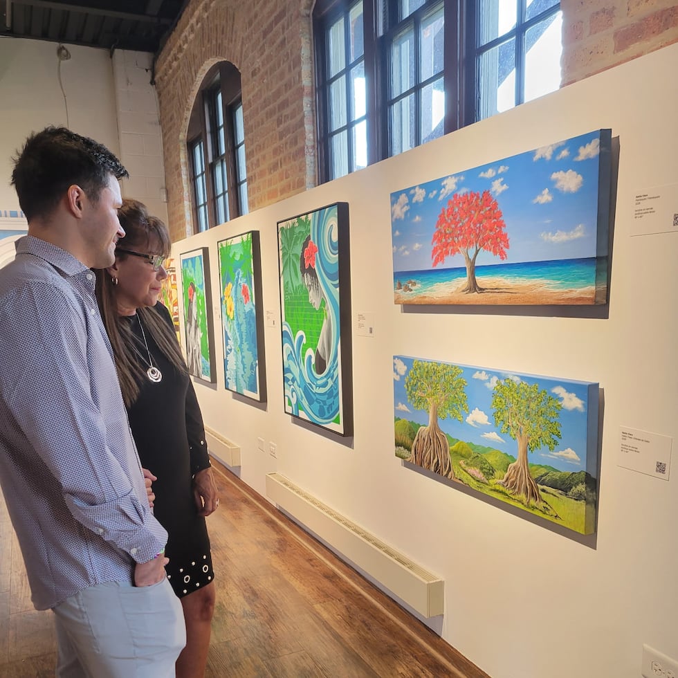 Artista Nettie Viera admira sus piezas "Flamboyán" y "Ceiba Trees" en la recepción de apertura de la exhibición "Nuestra Isla de Tesoros: Voces Puertorriqueñas de Indiana" en el Museo Nacional de Arte y Cultura Puertorriqueña en Chicago, IL.